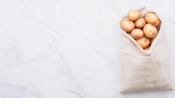 Fresh Potatoes in Linen Bag on Marble Surface for Farm-to-Table Concept and Rustic Kitchen Design photo
