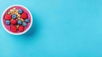 Vibrant Acai Bowl with Fresh Fruits and Granola on Blue Background for Healthy Lifestyle Concept photo