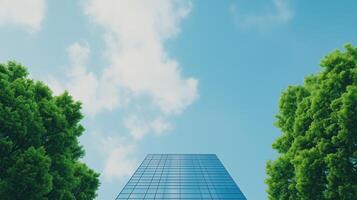 Sustainable Business Concept With Skyscraper Reflecting Blue Sky Amidst Green Trees Highlighting Environmental Social Governance Themes In Modern Architecture photo