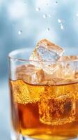 Slow Motion Macro Shot of Ice Cubes Splashing Into Refreshing Beverage Glass with Bubbles and Droplets in Crisp Focus Against Soft Blue Background for Dynamic Drink Presentation photo