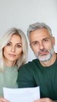 Middle Aged Couple Discussing Financial Issues and Budgeting Challenges While Looking Concerned in a Home Setting to Highlight Economic Stress and Family Money Management Discussions photo