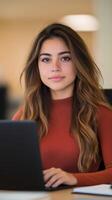 Young Woman Working at Desk in Modern Office Space with Laptop and Warm Lighting, Focused and Professional Setting for Business and Productivity photo