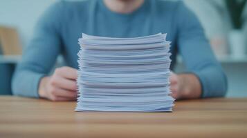 Stack of Paperwork on Desk with Person Sitting Behind in Blue Shirt Home Office Organization photo