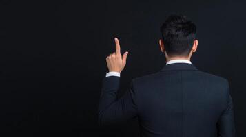 Business Professional in Formal Suit Presenting on Stage with Confidence and Authority in a Conference Setting with Black Background for Corporate Audience Engagement, Education, and Public Speaking photo