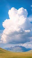 Majestic Clouds Forming Over Breathtaking Mountain Range Under Clear Blue Sky with Verdant Landscape photo