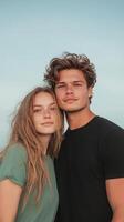 Young couple standing close together outdoors with a soft blue sky in the background. Portrait concept of love and togetherness photo