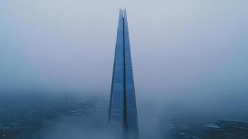 Aerial View of The Shard Tower in Foggy London Cityscape Featuring Iconic Architecture and Overcast Skyline photo