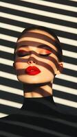Fashion Model with Striking Red Lipstick and Bold Eye Makeup in Dramatic Shadow and Light Patterns for Edgy Beauty and Trendy Editorial Style photo