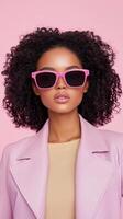 Stylish Woman Posing in Pink Sunglasses and Leather Jacket Against Pink Background in Studio Portrait Vertical View photo