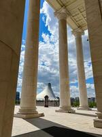 View of Khan Shatyr through the columns of State Opera and Ballet Theatre in Astana photo