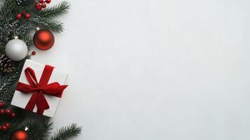 Christmas Themed Background With Festive Ornaments and Gift Featuring Red Ribbon on White Backdrop With Pine Sprigs for Holiday Design and Celebration Offers photo