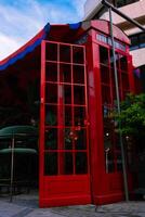Traditional now extinct old red telephone box from England in Cypriote cafe photo