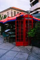 Traditional now extinct old red telephone box from England in Cypriote cafe photo