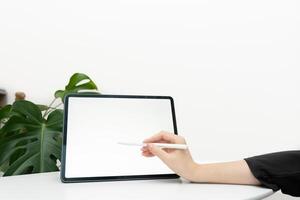 Overhead shot, A female using stylus pen drawing graphic art work on digital tablet computer on modern marble office table background. tablet blank screen mockup. photo