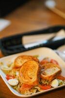 Caesar chicken salad with grated parmesan on white table photo