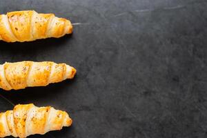 Delicious crispy three croissants on a black background. A low-key shot of food. photo