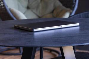 laptop on a round table with an outdoor background. Mockup design, for business, remote work, or modern workspace themes. photo
