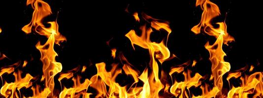 Tongues of bright flame rising upwards against a black background, creating the effect of movement and warmth photo