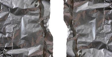 Crumpled sheet of gray foil for packaging products with torn edges on a isolated background photo