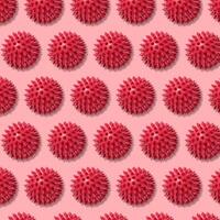 Round red ball with spikes, animal toy or massager. Repeating pattern photo