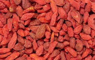 Pile of dry red goji berries on isolated background, close up photo