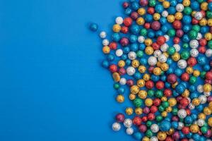 Vibrant multicolored glitter balls on a bright blue background with copy space photo