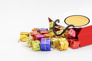 Miniature colorful gift boxes spill out of a decorative shopping bag photo