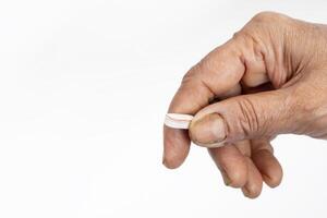 Close-up of a hand holding a damaged pill on a white background photo