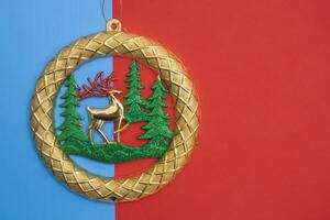 Golden Christmas ornament with reindeer on a red and blue background photo
