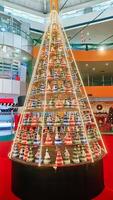 A stunning Christmas tree with colorful triangular decorations and lights displayed inside a mall, creating a festive holiday atmosphere photo