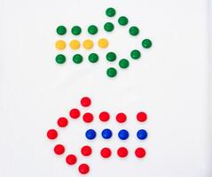 Two colorful arrows made from candy pieces on a white background, symbolizing direction, choice, or contrast in vibrant design photo
