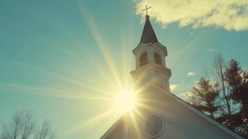 Church Tower with Cross and Sun Behind Creating Lens Flare photo