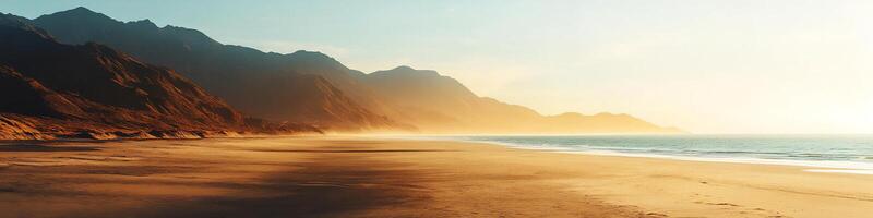 Golden sunrise over a tranquil beach with majestic mountains and calm ocean views photo