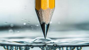 Tip of Sharp Pencil Submerging Under Water Close Up photo