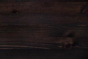 Dark wooden texture with visible grain and knots, perfect for backgrounds. photo