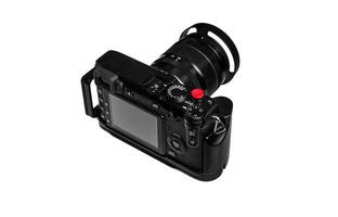 A black digital camera with a large lens and a red shutter button, viewed from the back, showing the LCD screen and various control buttons. photo