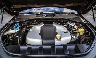 A close-up view of a modern car engine under the hood, showcasing the intricate components and design. photo