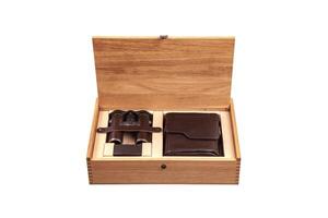 A wooden box with an open lid reveals a set of binoculars and a leather case, both neatly placed in compartments, showcasing a luxurious and organized presentation photo