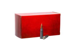 Red ammunition box with two rifle cartridges standing in front of it, isolated on a white background, representing firearms, hunting. photo