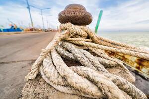 Old Mooring Post with Rope and Tire on a Seaside Pier3 photo