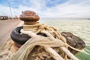 Old Mooring Post with Rope and Tire on a Seaside Pier3 photo