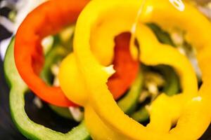 Vibrant Close-Up of Freshly Sliced Bell Peppers in Red, Green, and Yellow Colors - Showcasing the Richness of Fresh Vegetables photo