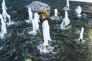 Relaxing Water Fountain with Bubbling Jets and Natural Rock Features in Peaceful Setting photo