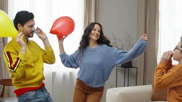 Friends enjoying a lively indoor gathering at home with balloons and laughter video