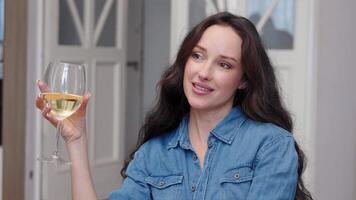 Enjoying a glass of white wine while smiling at home in the evening video