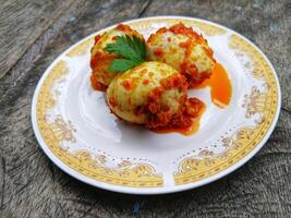 Egg Balado. Balado is a type of hot and spicy bumbu spice mixture found in Indonesian cuisine. Balado sauce is made by stir frying ground red hot chili pepper with other spices photo