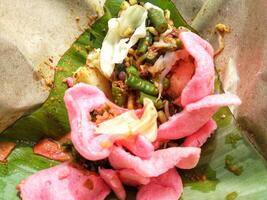 Close up view of Lotek, Indonesian traditional food made from boiled vegetable with peanut sauce served with crackers photo