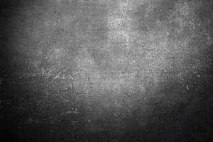 Dark textured surface with subtle scratches, specks, and grunge effect, ideal for backgrounds or design projects. photo