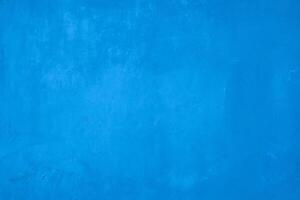 A vibrant blue painted wall with subtle texture, ideal as a minimalist background for creative and design projects. photo