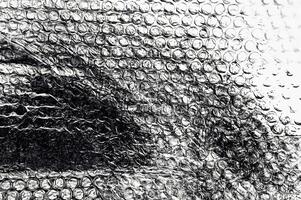 Close-up of bubble wrap in black and white, showing detailed textures and abstract patterns for creative use. photo